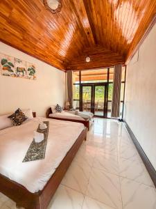 a bedroom with two beds and a living room at Views Backpackers Hostel in Nongkhiaw