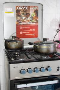 two pots sitting on top of a stove at Ziwa View studio Apartments in Goat Island