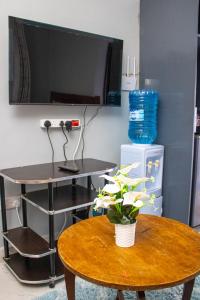 a room with a table and a tv on a wall at Ziwa View studio Apartments in Goat Island