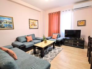 a living room with a couch and a tv at Shkodra Apartments in Shkodër