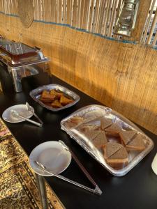 ein Tisch mit einem Tablett Brot und einem Teller Essen in der Unterkunft Sand Camp Oman in Badīyah