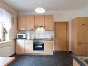 a kitchen with a stove and a microwave at Cozy Apartment in Ore Mountains with Balcony in Breitenbrunn