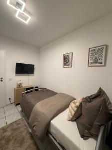 a bedroom with a bed and a flat screen tv at Gaststätte Seehaus Maroth in Maroth