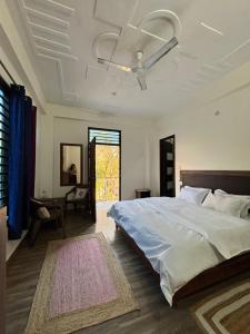 a bedroom with a bed and a ceiling fan at Holistic House in Dharamshala