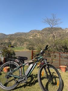 a bike parked on the grass next to a river at Lake 1 Estate in Morni
