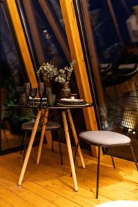 a small table with chairs and flowers on it at Funky Cabins Villas and Chalets - Gaia Park in Tirana