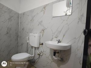 a bathroom with a toilet and a sink at Sandy Steps in Varkala