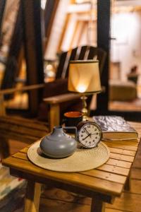 a table with a lamp and a clock on it at Funky Cabins Villas and Chalets - Gaia Park in Tirana