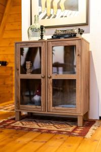 a wooden cabinet with glass doors in a room at Funky Cabins Villas and Chalets - Gaia Park in Tirana