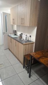 a kitchen with wooden cabinets and a table in it at Apartment 1 at Busy Bee in Daingean