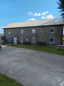 a brick building with two benches in front of it at Apartment 1 at Busy Bee in Daingean