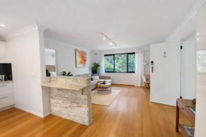 a living room with white walls and a fireplace at Coastal Stay in Cronulla +5 photos