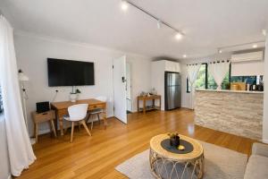 a living room with a table and a dining room at Coastal Stay in Cronulla