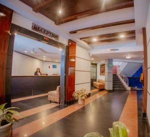 a lobby of a hospital with a woman in the background at Om Shiv Hotel Formerly The Treat Hotel in Madgaon