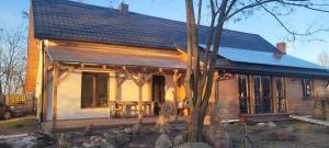 a wooden house with a porch and a table at Esterka Village in Esterka