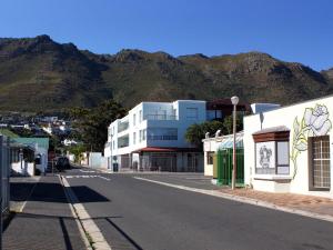an empty street in a town with mountains in the background at Sea Urchin in Gordonʼs Bay