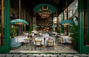 a restaurant with white tables and chairs and blue umbrellas at Andaz Shanghai ITC in Shanghai