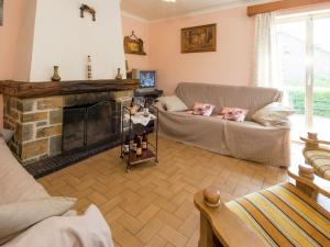 uma sala de estar com um sofá e uma lareira em Famililale ideal home for family gatherings em Lierneux