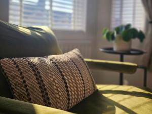 a couch with a pillow and a plant on a table at Saint Margaret's Guest House - Comfortable Rooms in a Quiet Area Close to the Heart of Poole - Free Parking & Fast Wifi in Poole