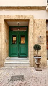 a green door of a building with a plant in front at Centrum Hotel - City Center in Nicosia