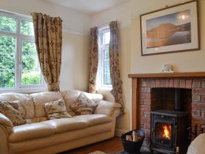 a living room with a couch and a fireplace at Bevan House in Llansaintfraed in Elvel