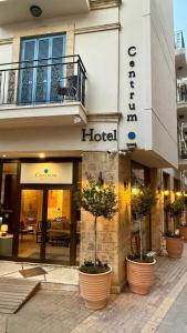a hotel building with potted plants in front of it at Centrum Hotel - City Center in Nicosia