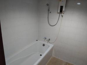 a white bathroom with a tub and a shower at โรงแรมโกลเด้นอินน์ in Chachoengsao +21 photos