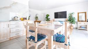 a kitchen with a wooden table and chairs at Huis Marais in Herolds Bay