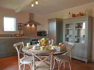 a kitchen with a table and chairs in a kitchen at Magnificent farmhouse with private pool and garden in Roussières
