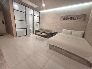 a hotel room with a bed and a chair at Hotel Terry's in Suwŏn-yŏk