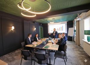 a group of people sitting around a table in a meeting room at Hotel Le Mont Medical & SPA Adults Only in Świeradów-Zdrój +45 photos