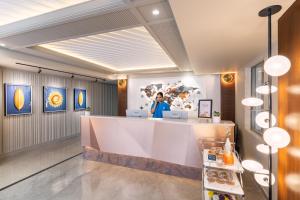 a woman standing at a counter in a restaurant at Foxtrail Sector 60 - AM Hotel Kollection, Gurgaon in Gurgaon