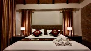 a bedroom with a large bed with two stuffed animals on it at Lao Asia Resort Luangprabang in Luang Prabang