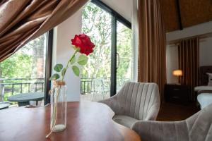 a vase with a rose in it sitting on a table at Lao Asia Resort Luangprabang in Luang Prabang