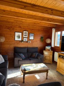 a living room with a couch and a coffee table at Chalet Tramontane, gîte tout confort in Xonrupt-Longemer