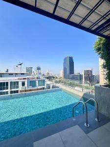 a large swimming pool on top of a building at Muay Thai Apartment - Ratchada in Bangkok