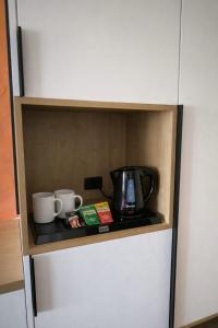 a cupboard with a coffee maker and two mugs at Sto Rija in Krk