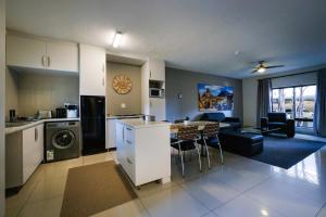 a kitchen and living room with a table and a dining room at Hillside Accommodation in Windhoek