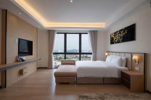 a hotel room with a bed and a television at Asteria Melaka by Attic Suite in Malacca +114 photos