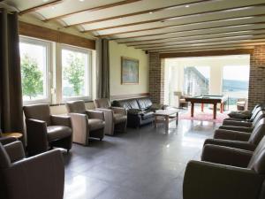 een wachtkamer met banken en een pooltafel bij Spacious and well cared for house with a panoramic view sauna and a summer pool in Habiemont