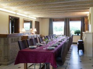 een lange eetkamer met een lange tafel en stoelen bij Spacious and well cared for house with a panoramic in Habiemont