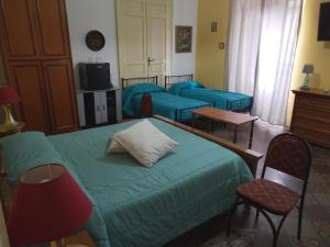 a bedroom with a bed and chairs and a tv at B&B Donna Elvira in Siderno Marina
