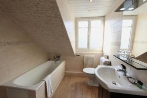a bathroom with a tub and a toilet and a sink at Hôtel Chopin in Paris +61 photos