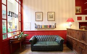 a living room with a leather couch and a table at Hôtel Chopin in Paris