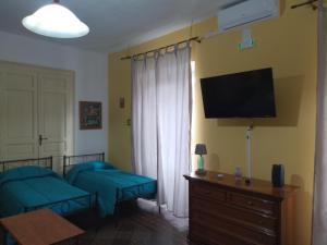 a living room with two beds and a tv at B&B Donna Elvira in Siderno Marina