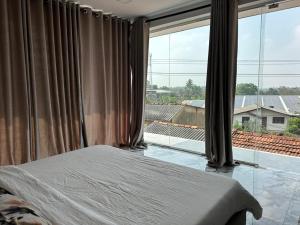 a bedroom with a bed and a large window at The calm villa in Kandana