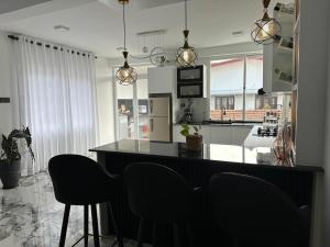 a kitchen with a black counter and chairs in it at The calm villa in Kandana +5 photos
