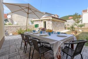 a table with chairs and an umbrella on a patio at Villa Elen in Ist