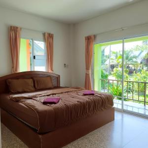 a bedroom with a large bed and a large window at Banmairimfungnamkohchang in Ban Dan Kao