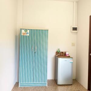 a green and white door next to a refrigerator at Banmairimfungnamkohchang in Ban Dan Kao